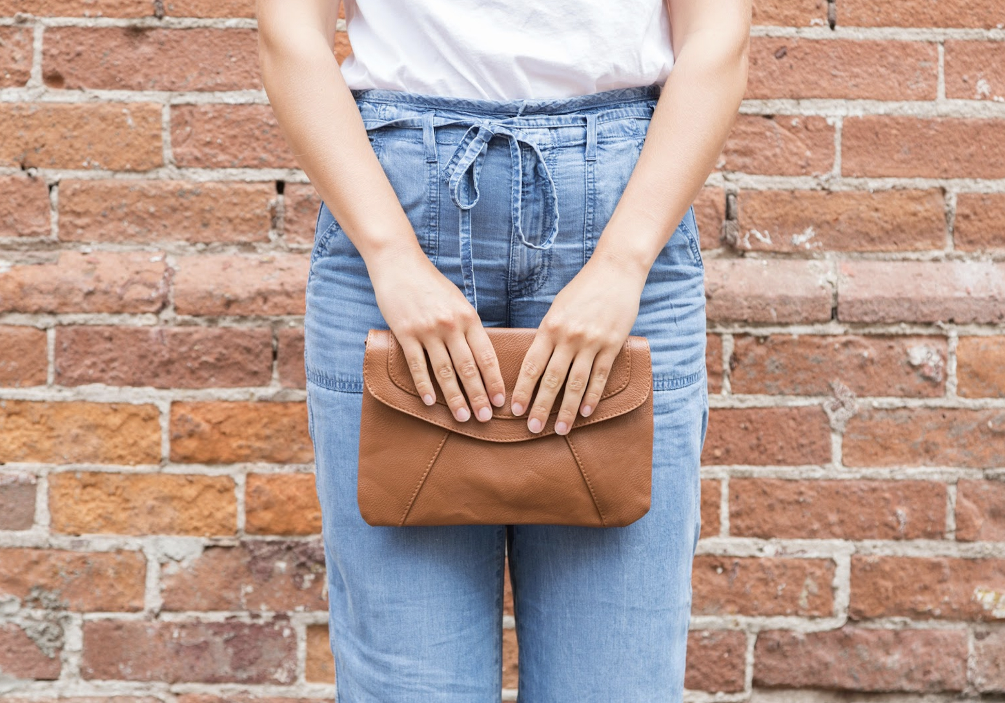 woman holding leather purse