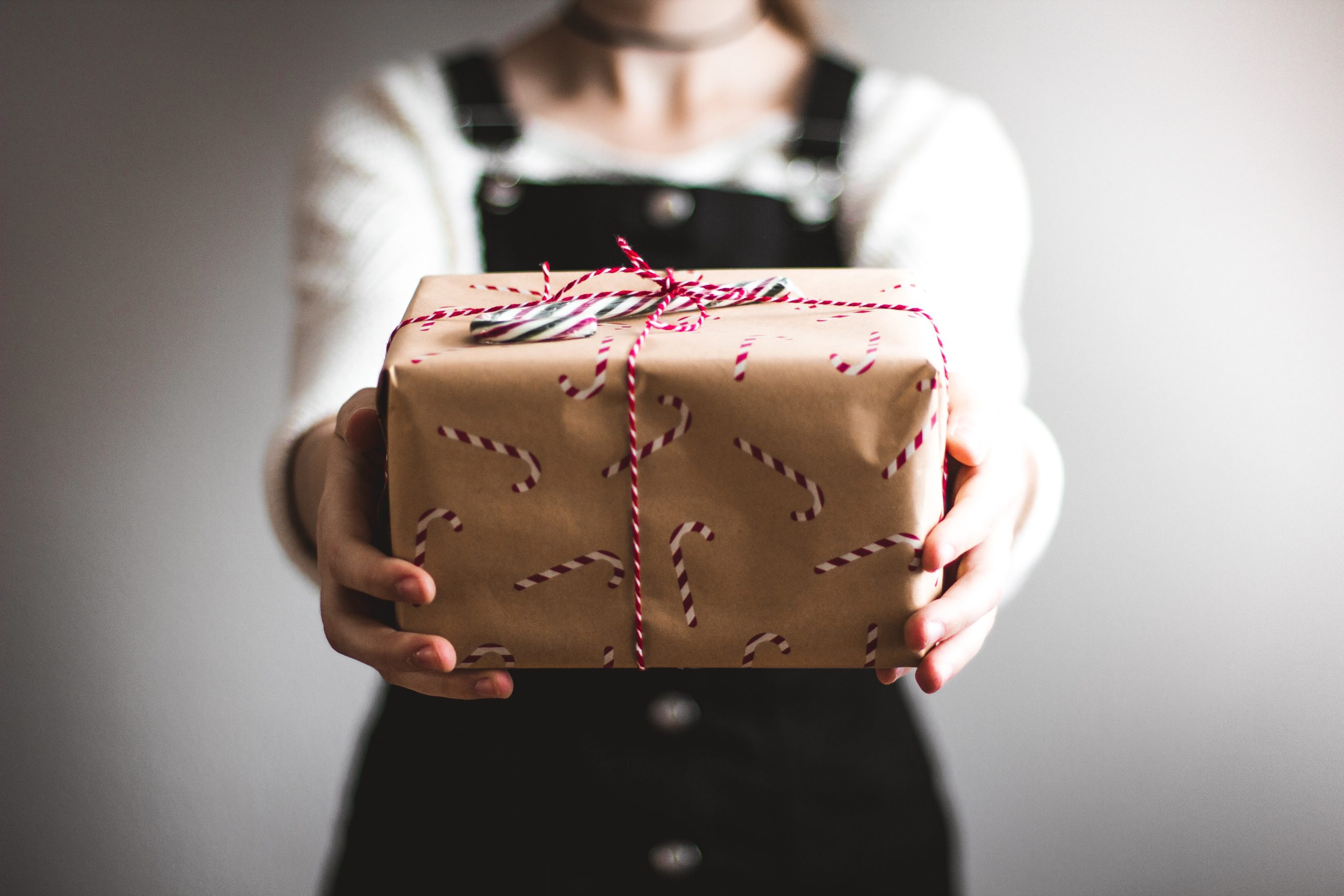 woman holding out wrapped Christmas present